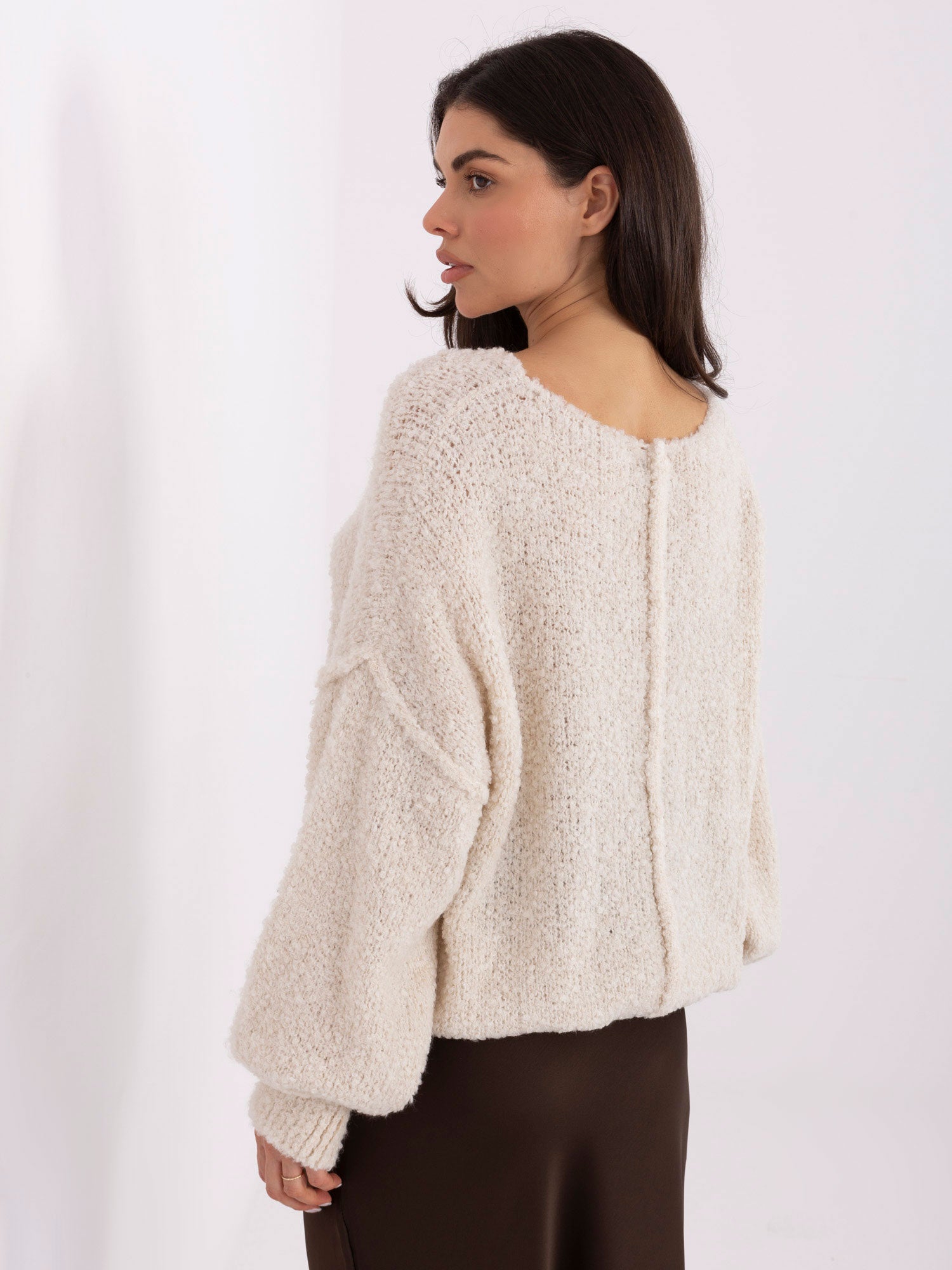 Jasnobeżowy damski sweter boucle z przeszyciami