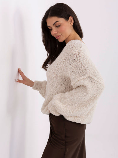 Jasnobeżowy damski sweter boucle z przeszyciami