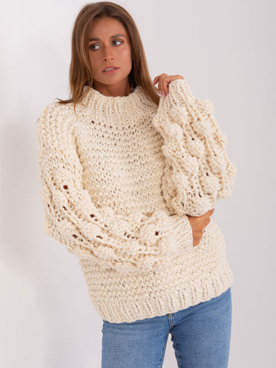 Jasnobeżowy sweter oversize z grubym splotem