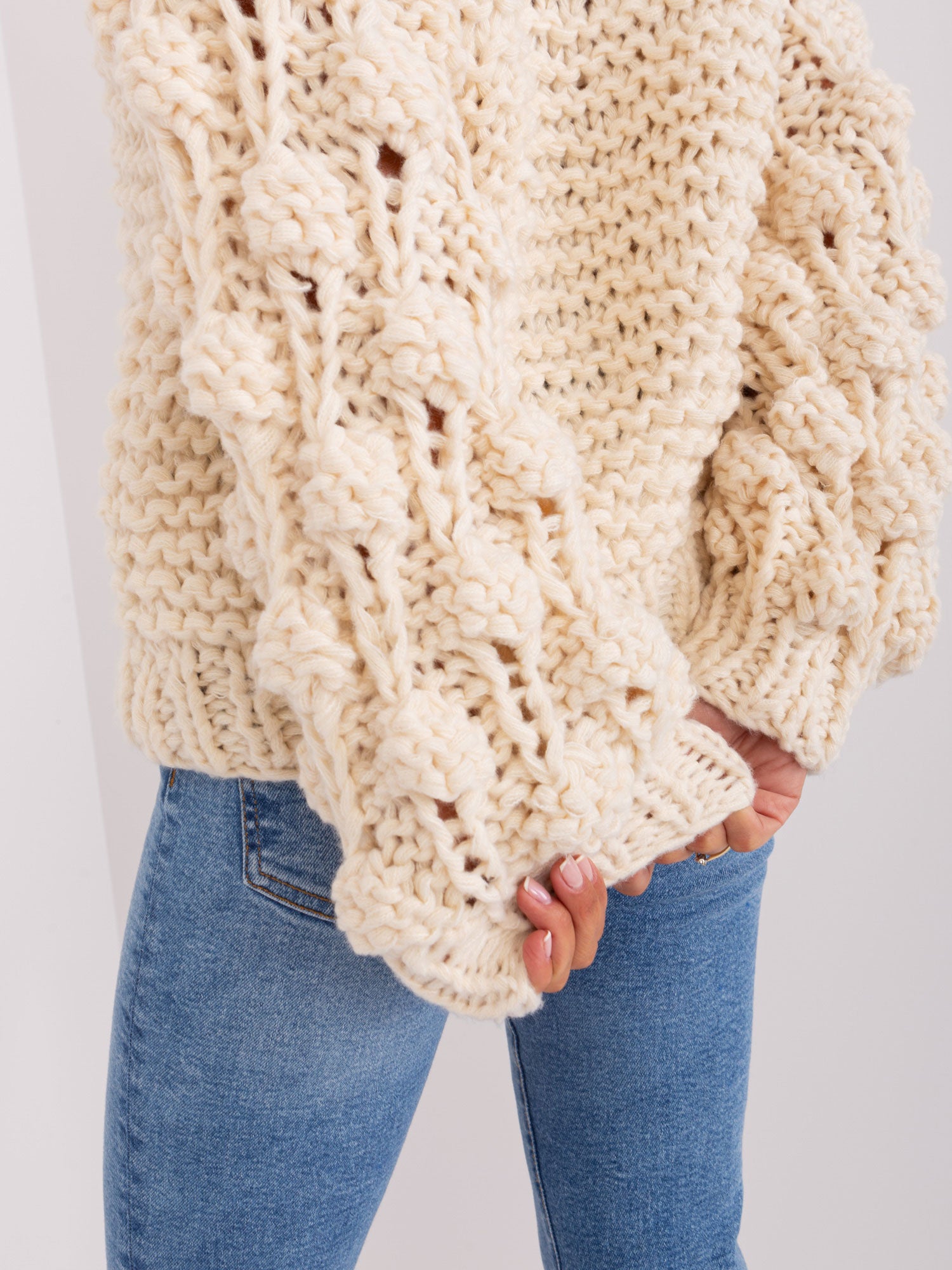 Jasnobeżowy sweter oversize z grubym splotem