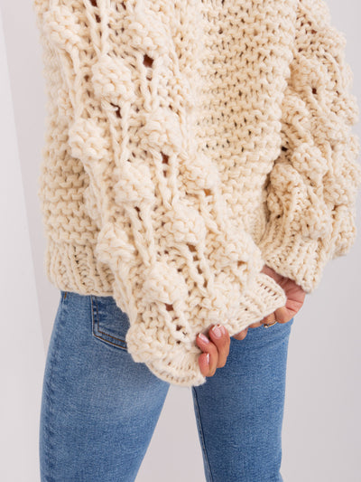 Jasnobeżowy sweter oversize z grubym splotem