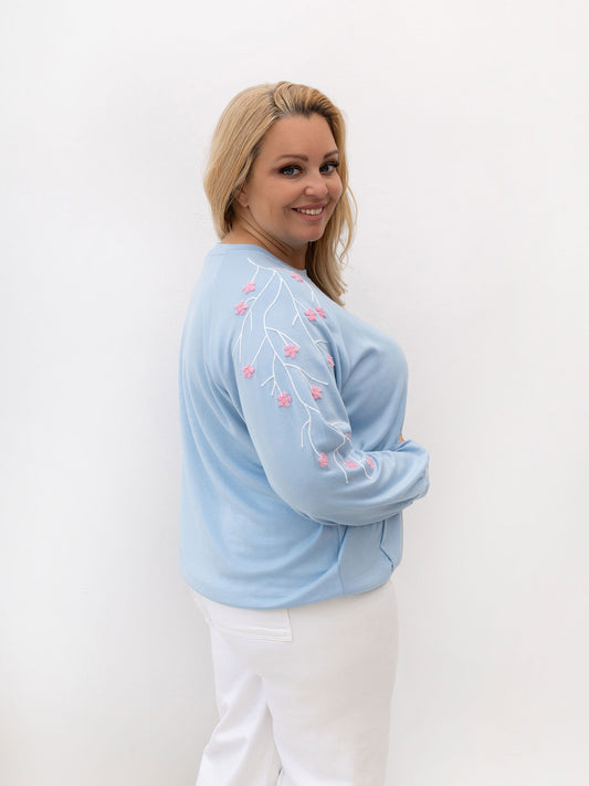 Jasnoniebieska bluza plus size z kwiatową aplikacją