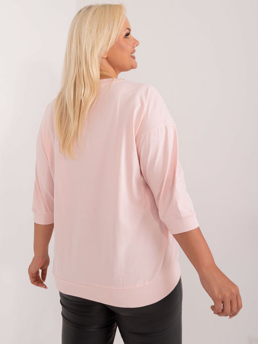 Jasnoróżowa bluzka plus size z aplikacją i napisem