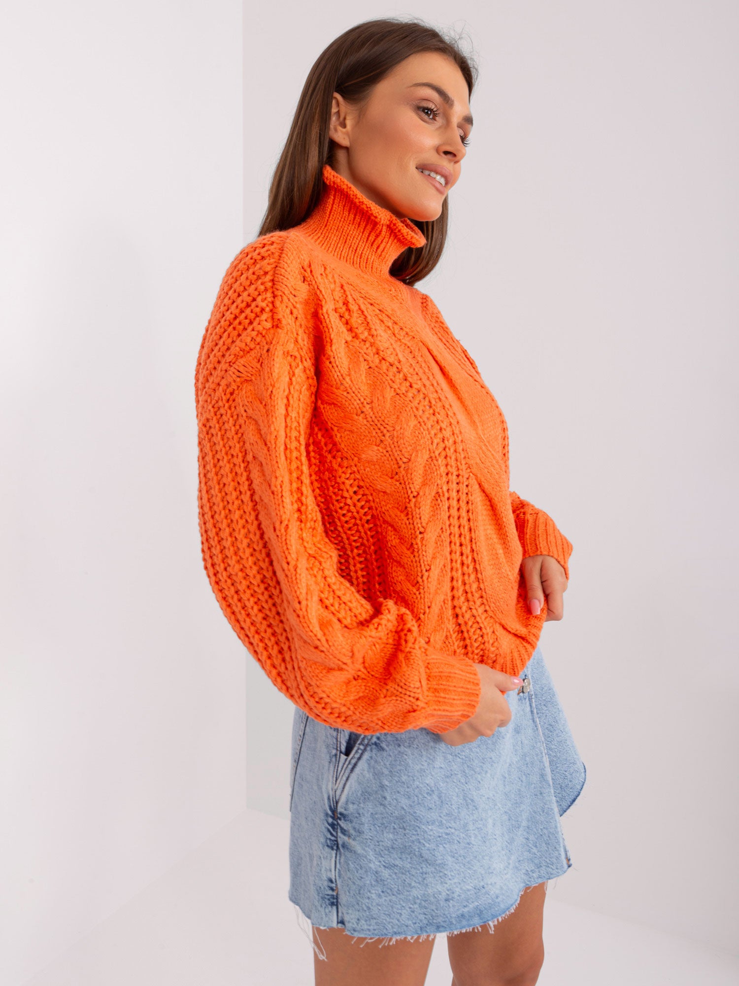 Pomarańczowy sweter oversize z warkoczami